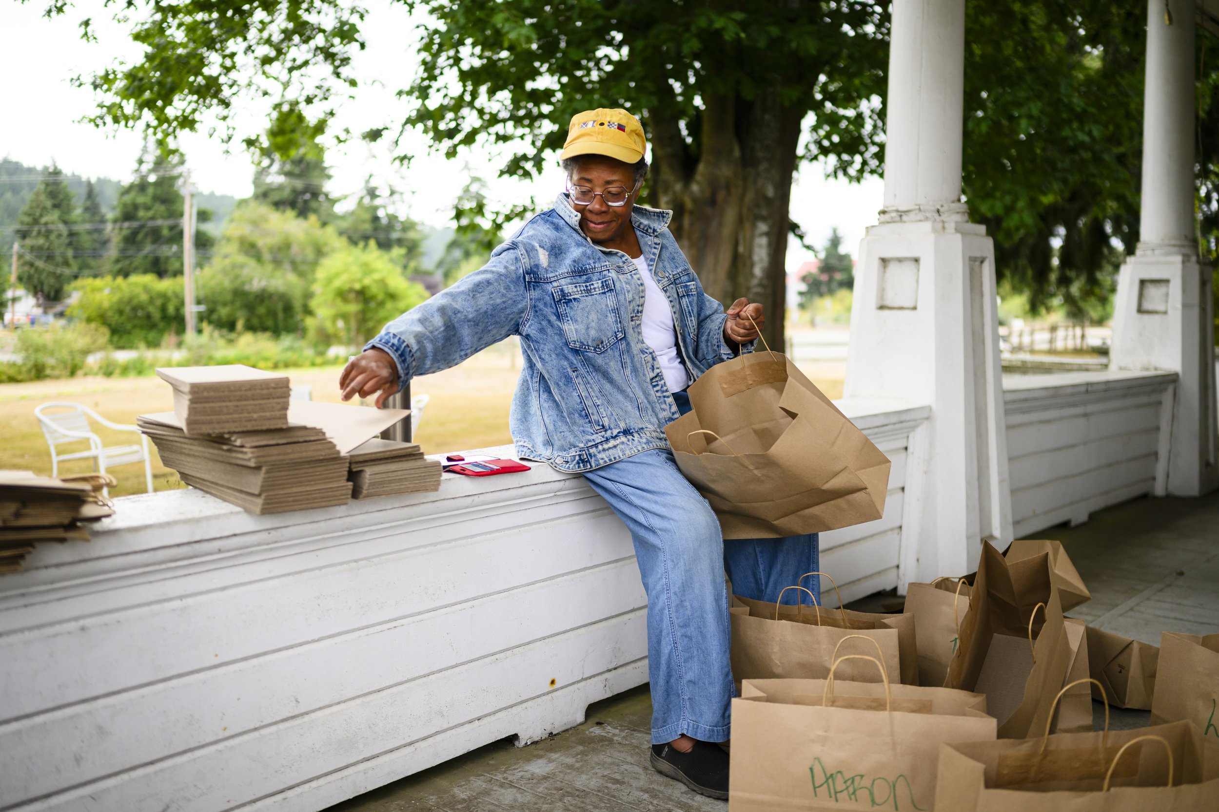   Oceana Sawyer prepares bags at the Nourishing Beloved Community distribution site at Finnriver Farm & Cidery. The program packs and distributes food purchased and donated from local growers and producers, with a goal of producing food by and for people of the global majority (PGM). Photo by Heather Johnson  