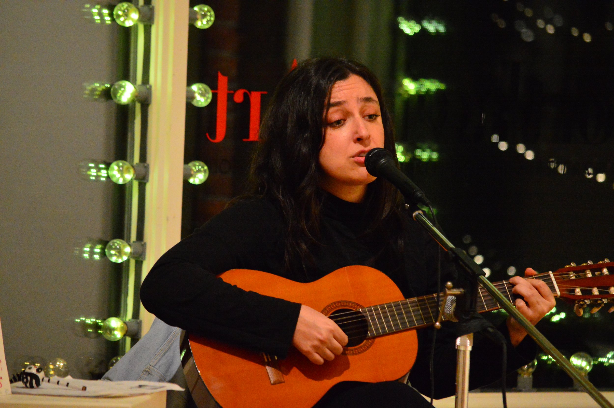   Northwind Art School staff member Leila Block in another persona: musician singing and playing at Northwind's Jeanette Best Gallery in December. Photo by Diane Urbani de la Paz  