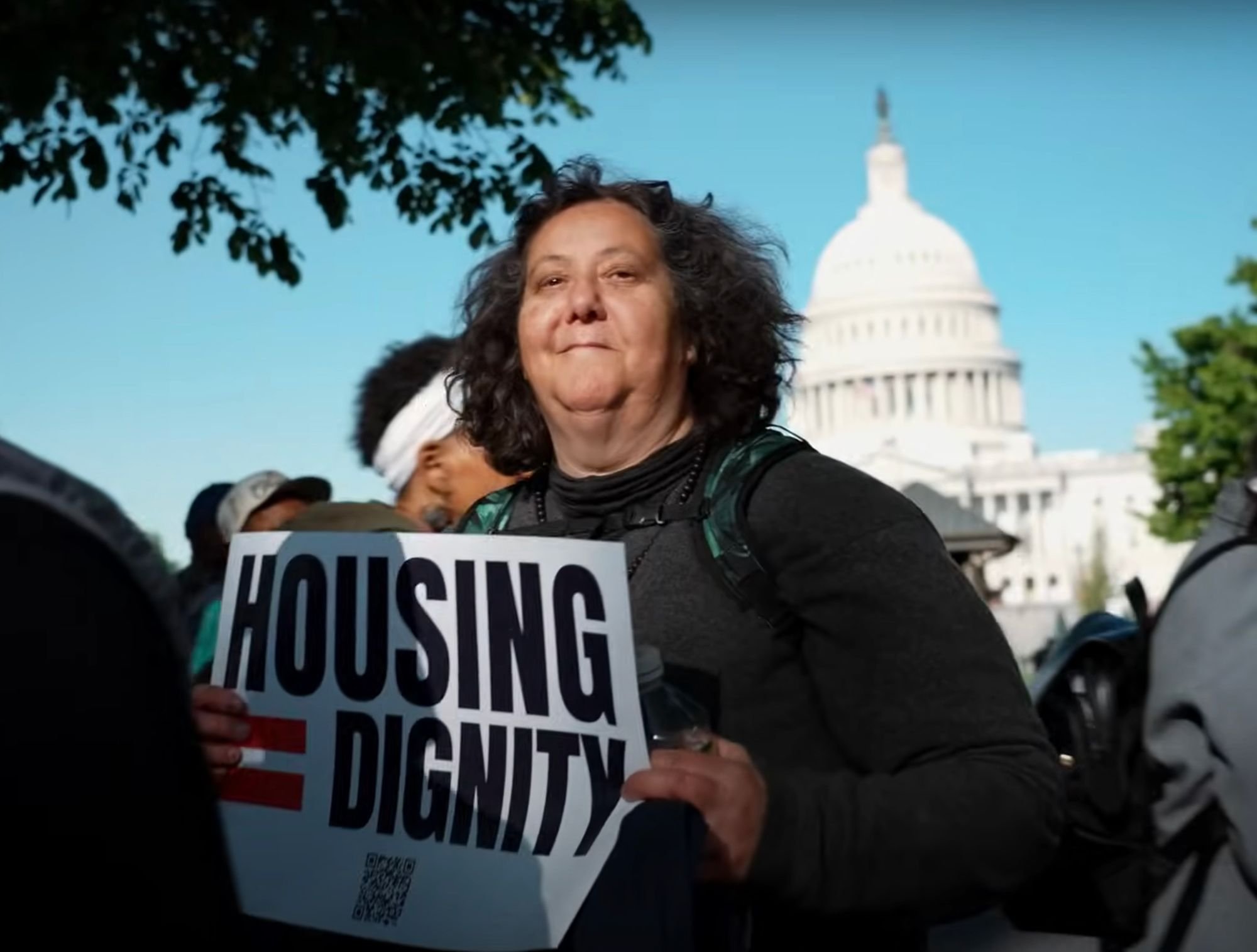   In a still from    a video by Invisible People   , Maggie G. stands before the United States Supreme Court alongside hundreds of other protestors. Photo courtesy of Invisible People  