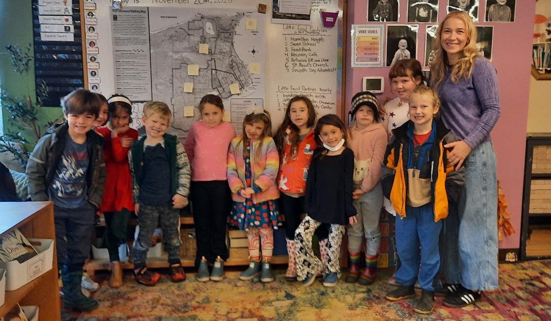 Katey Dwyer's (far right) Explorers class at Swan School aims to add at least five more food pantries to the town by the end of the school year. Behind the students is a map of where the current food pantries exist in town and the surrounding area. Photo by Kathie Meyer