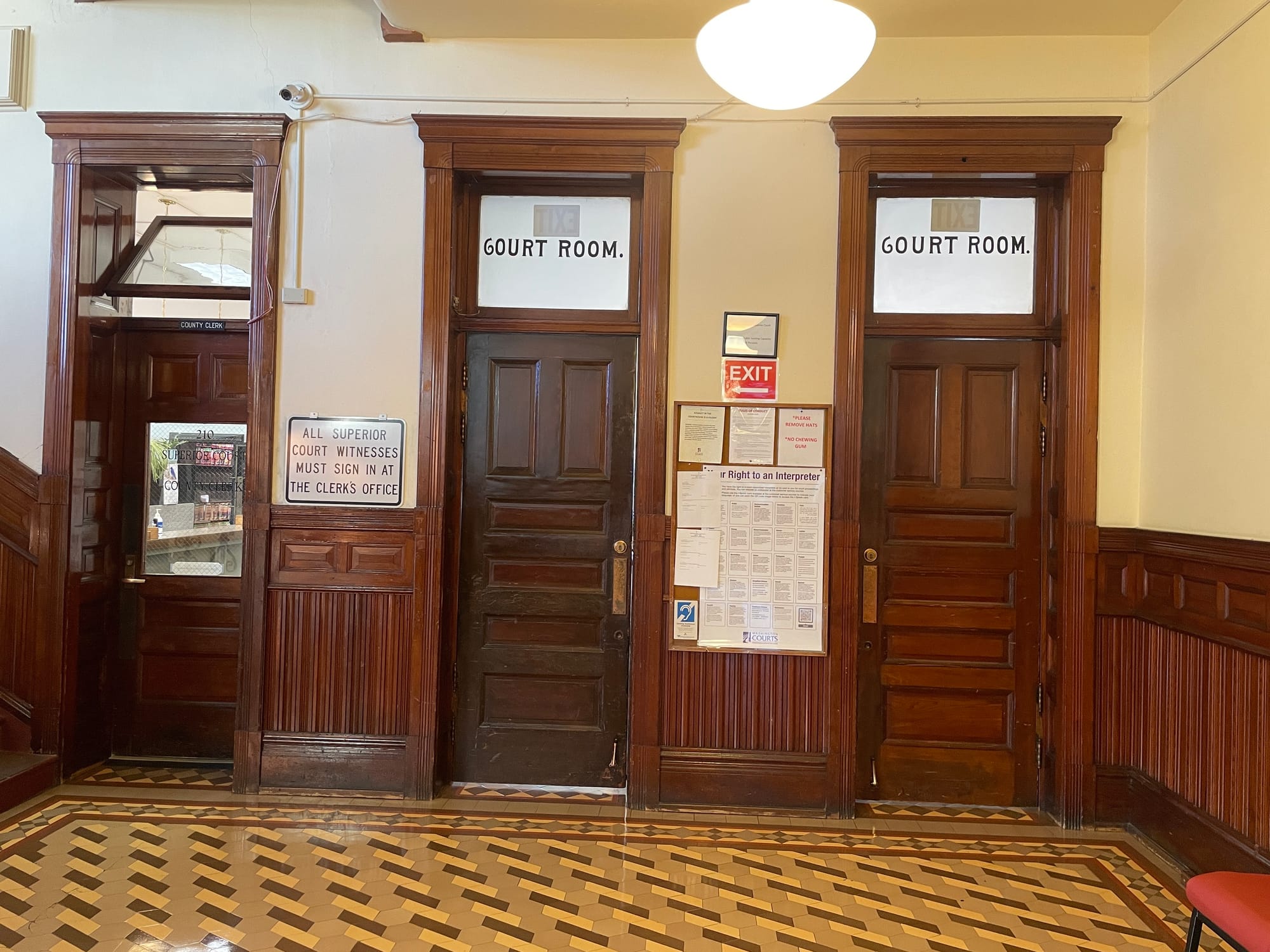 Superior Courtroom Doors, three tall brown wooden doors and brown tile