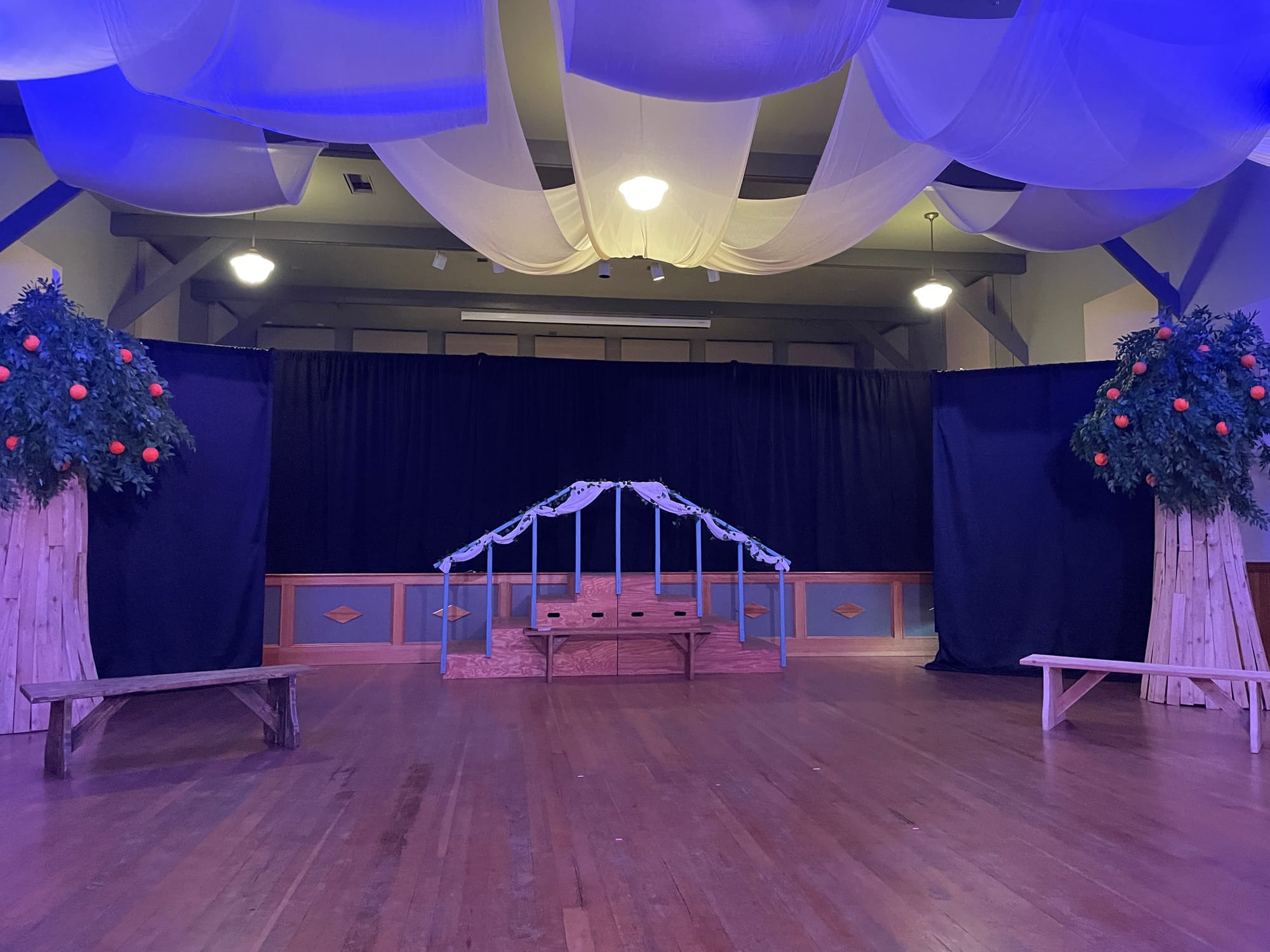 An empty stage with two benches and a staircase in the middle