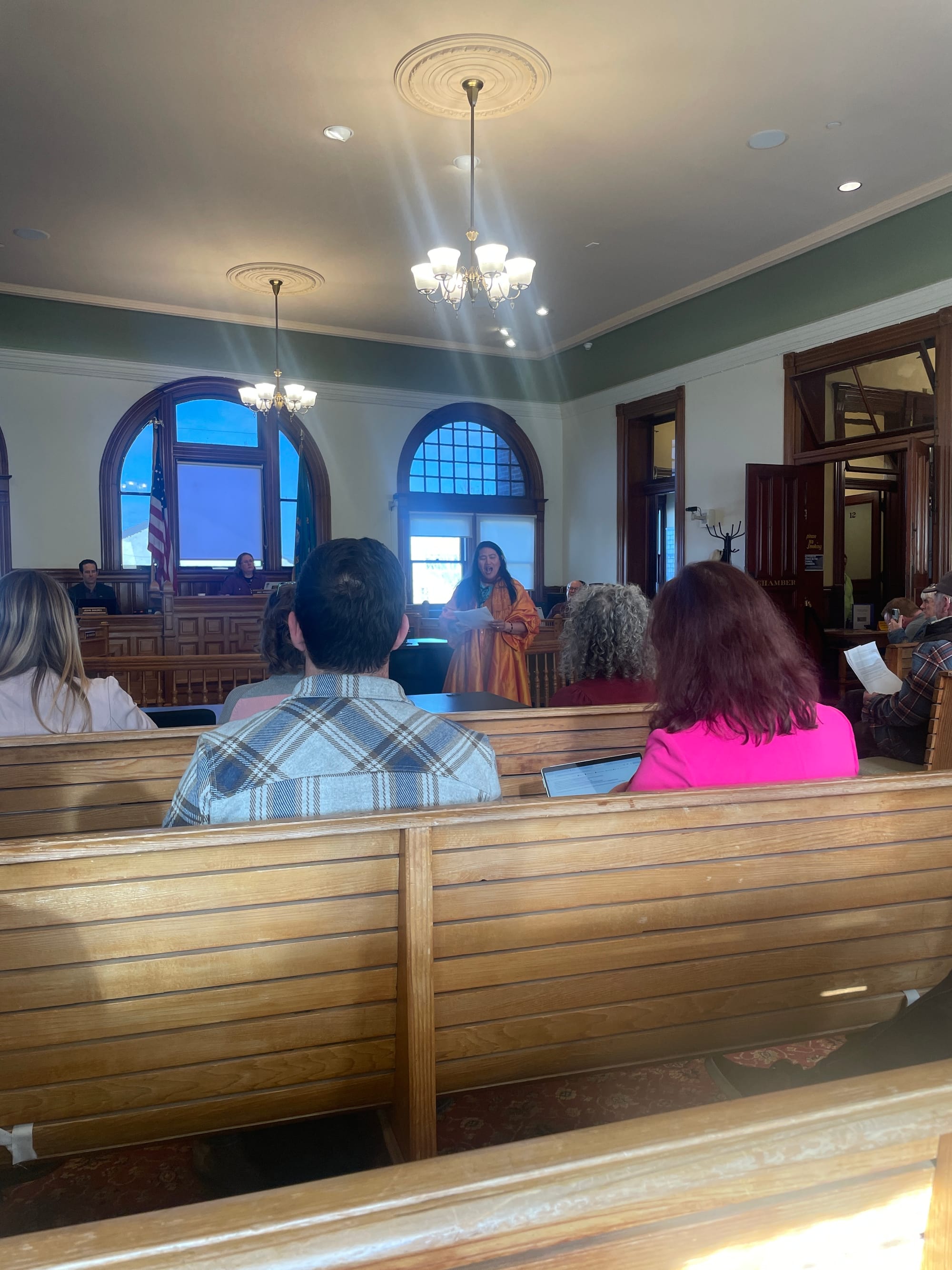 Poet Laureate Rufina Garay reading a poem in front of the city council.