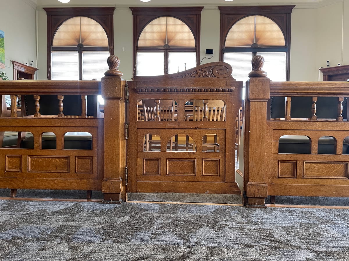 A wooden bannister in front of the judge's bench