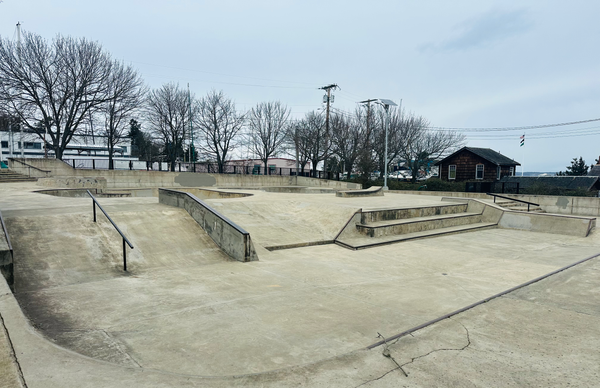 A picture of the Seamus Sims Skatepark, smooth gray concrete and rails for skateboarding